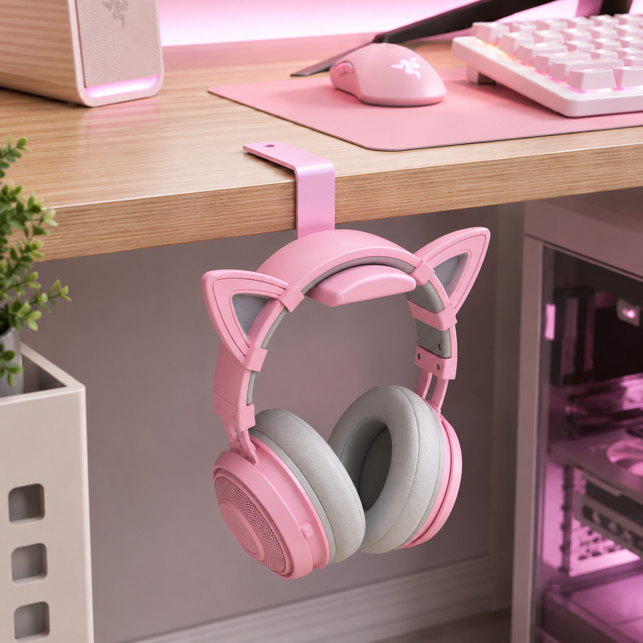 Pink headphone hanger installed under a gaming desk